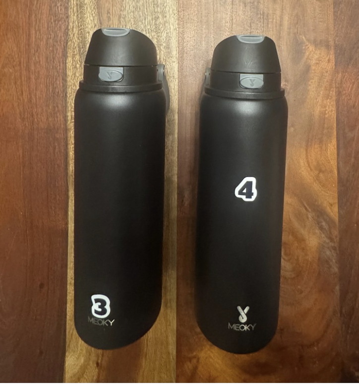 Customer photo of two matching black water bottles tagged 3 and 4 on a wood table